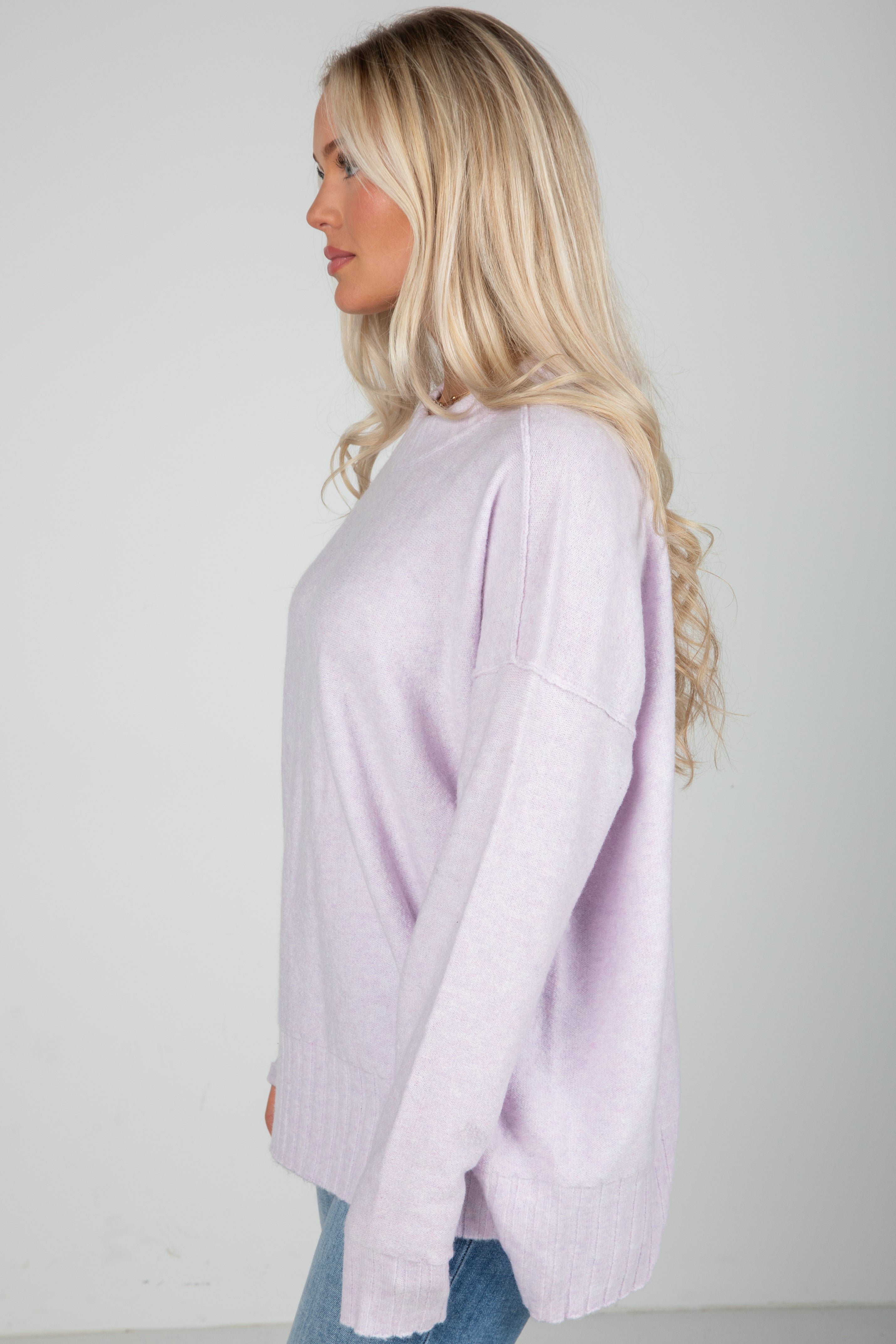 Woman wearing a light purple sweater against a plain background