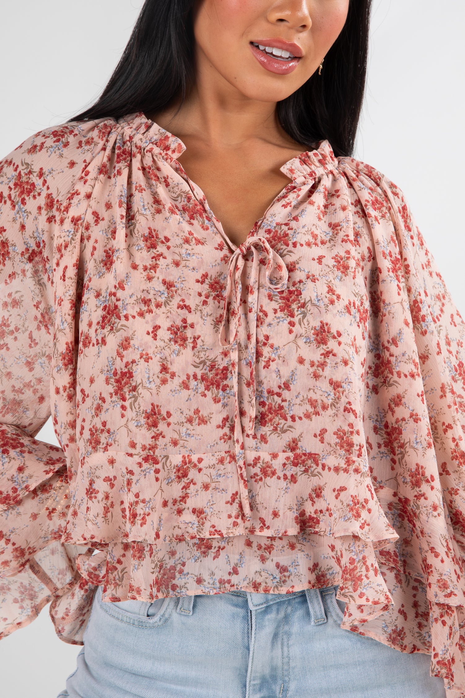 Woman wearing a floral blouse with a plain background