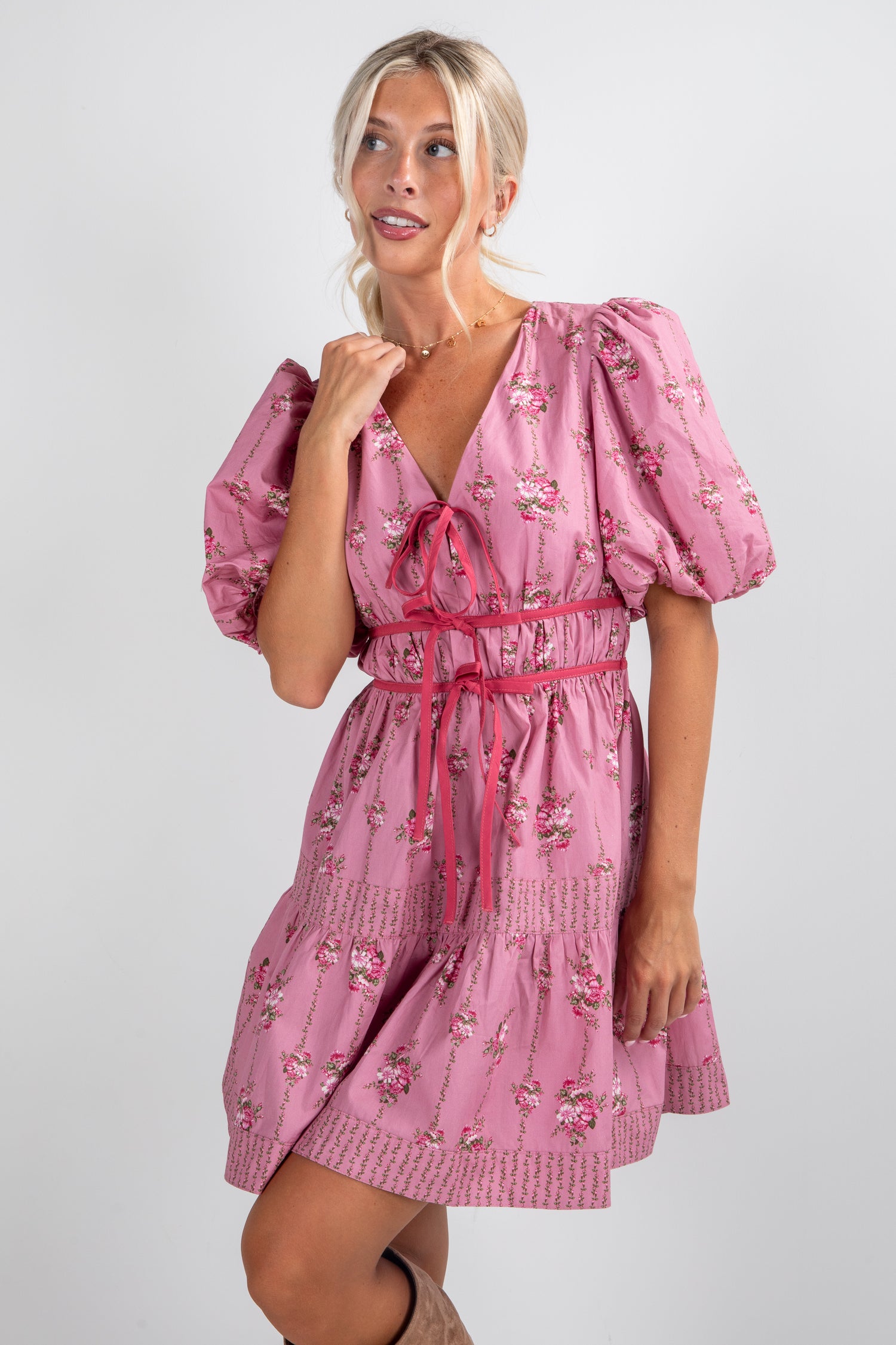 Woman wearing a pink floral dress on a white background