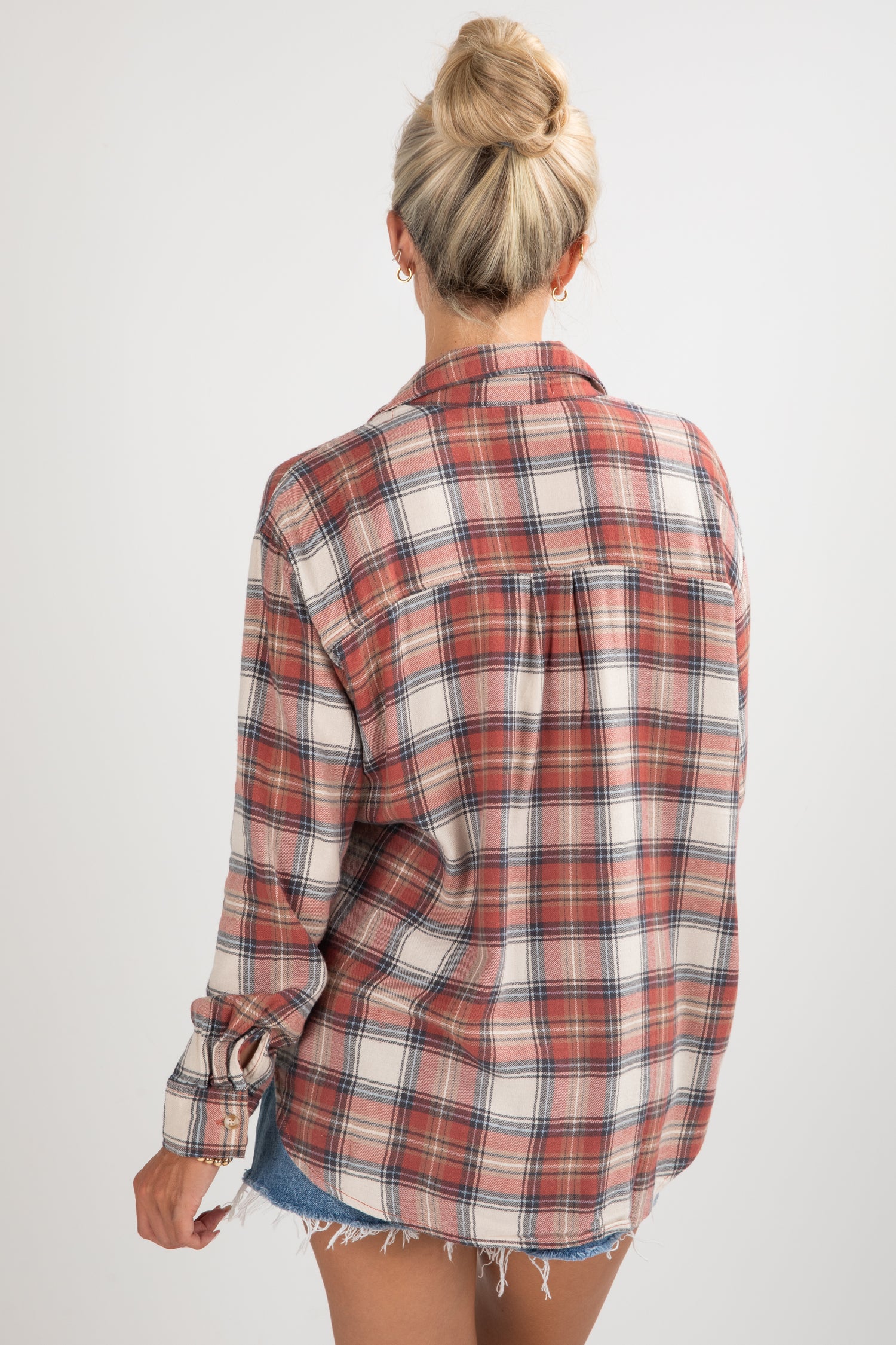 Person wearing a plaid shirt with a white background