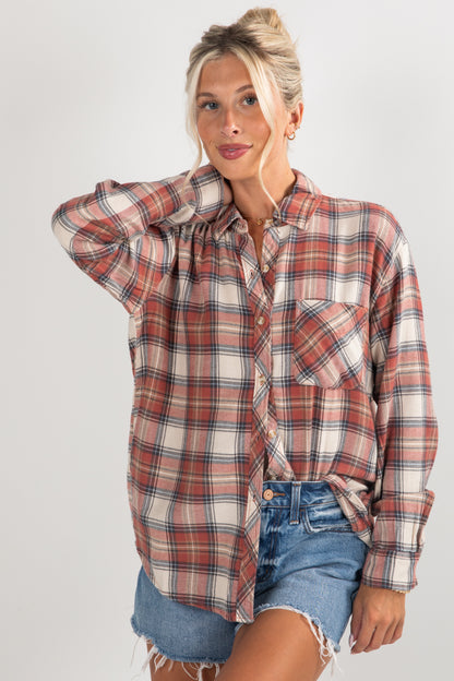 Woman wearing a plaid shirt and denim shorts on a plain background