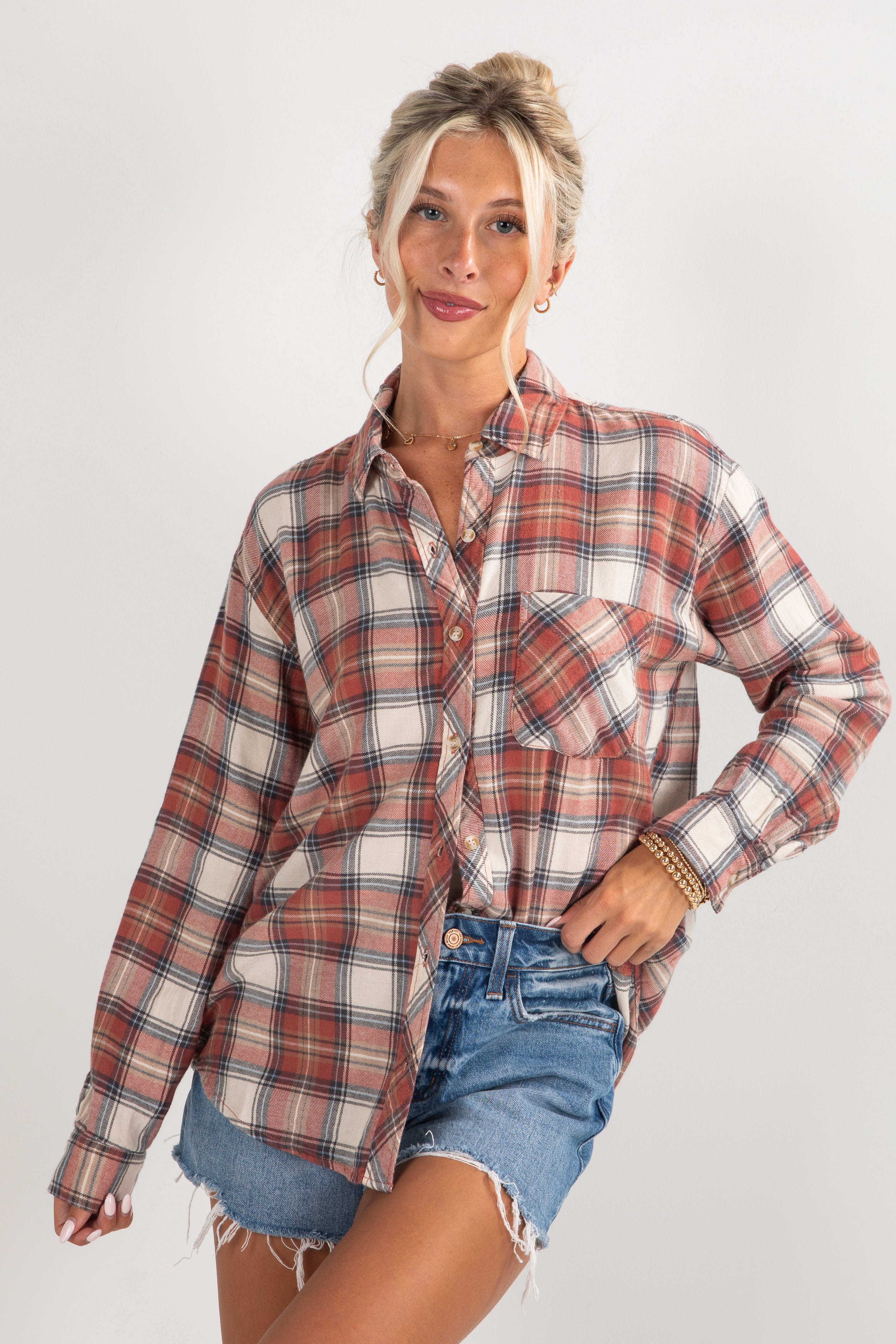 Woman wearing a plaid shirt and denim shorts on a white background