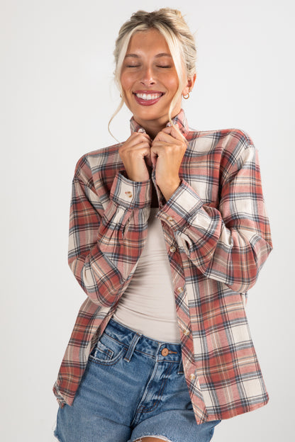 Woman wearing a plaid shirt and denim shorts on a white background