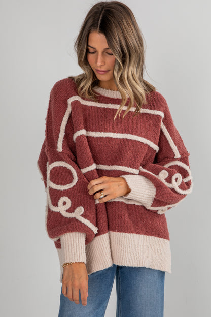 Woman wearing a maroon and beige sweater with &