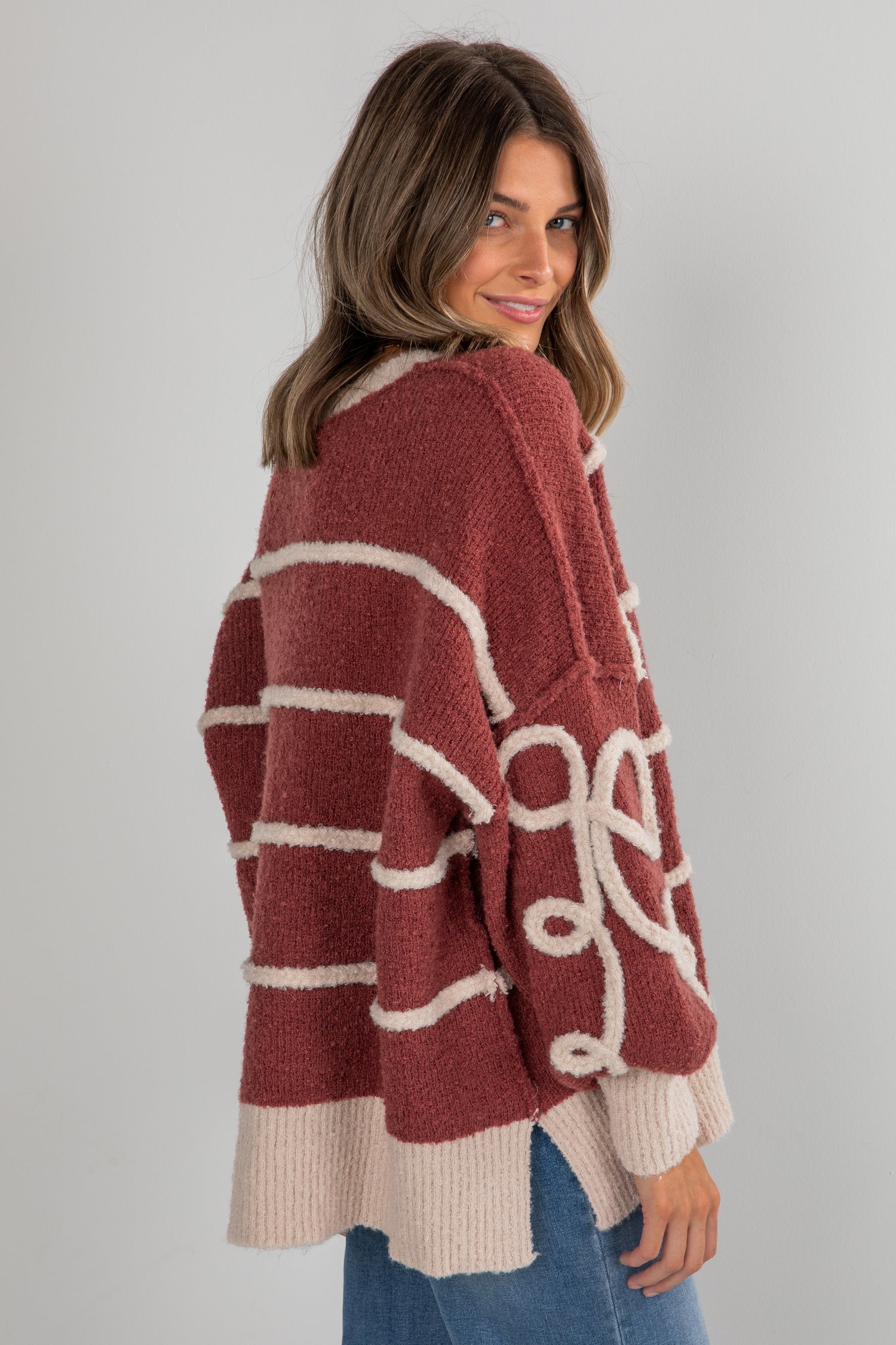 Woman wearing a red and beige cardigan with a white background