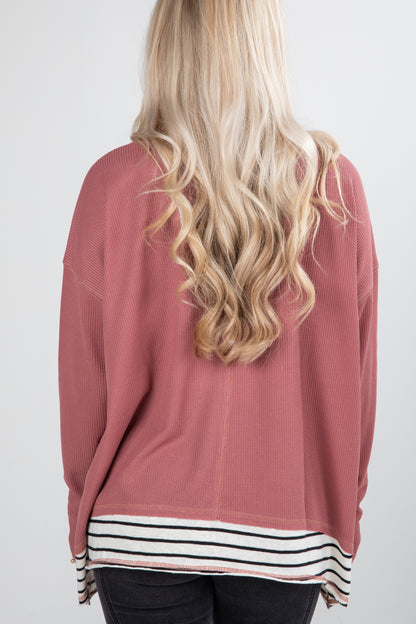 Person wearing a pink sweater with a white background