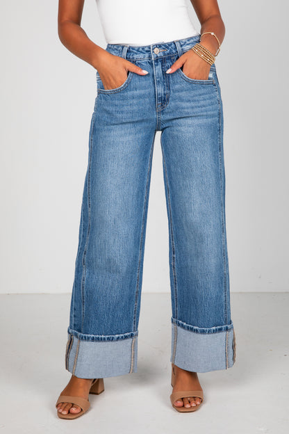 Person wearing blue wide-leg jeans on a white background