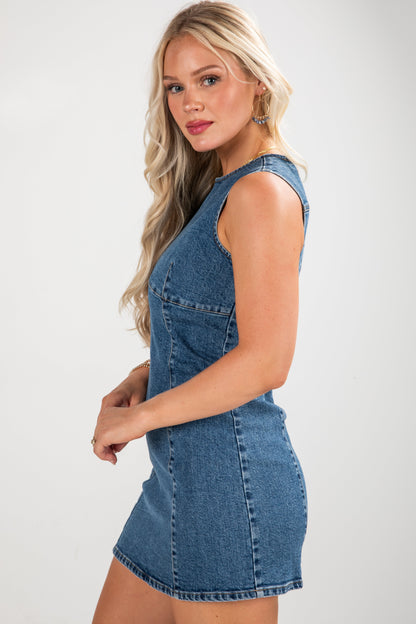 Woman wearing a denim dress against a plain background