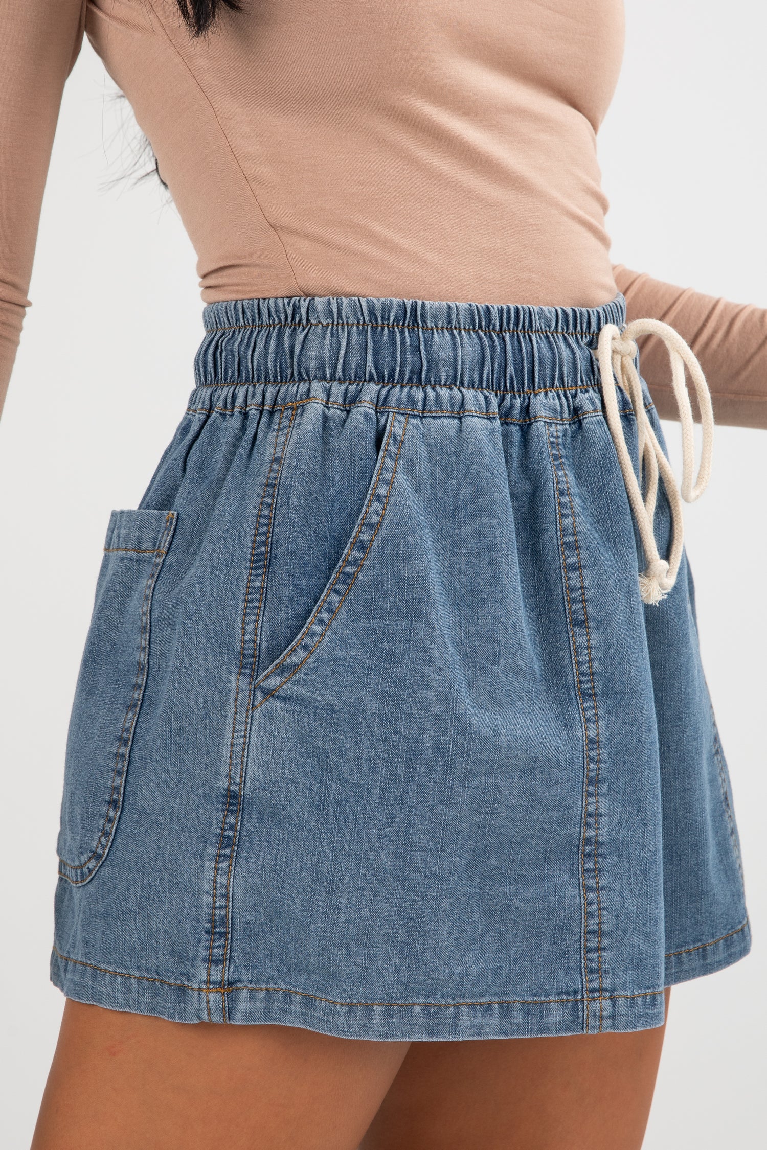 Denim skirt with drawstring waist on a plain background