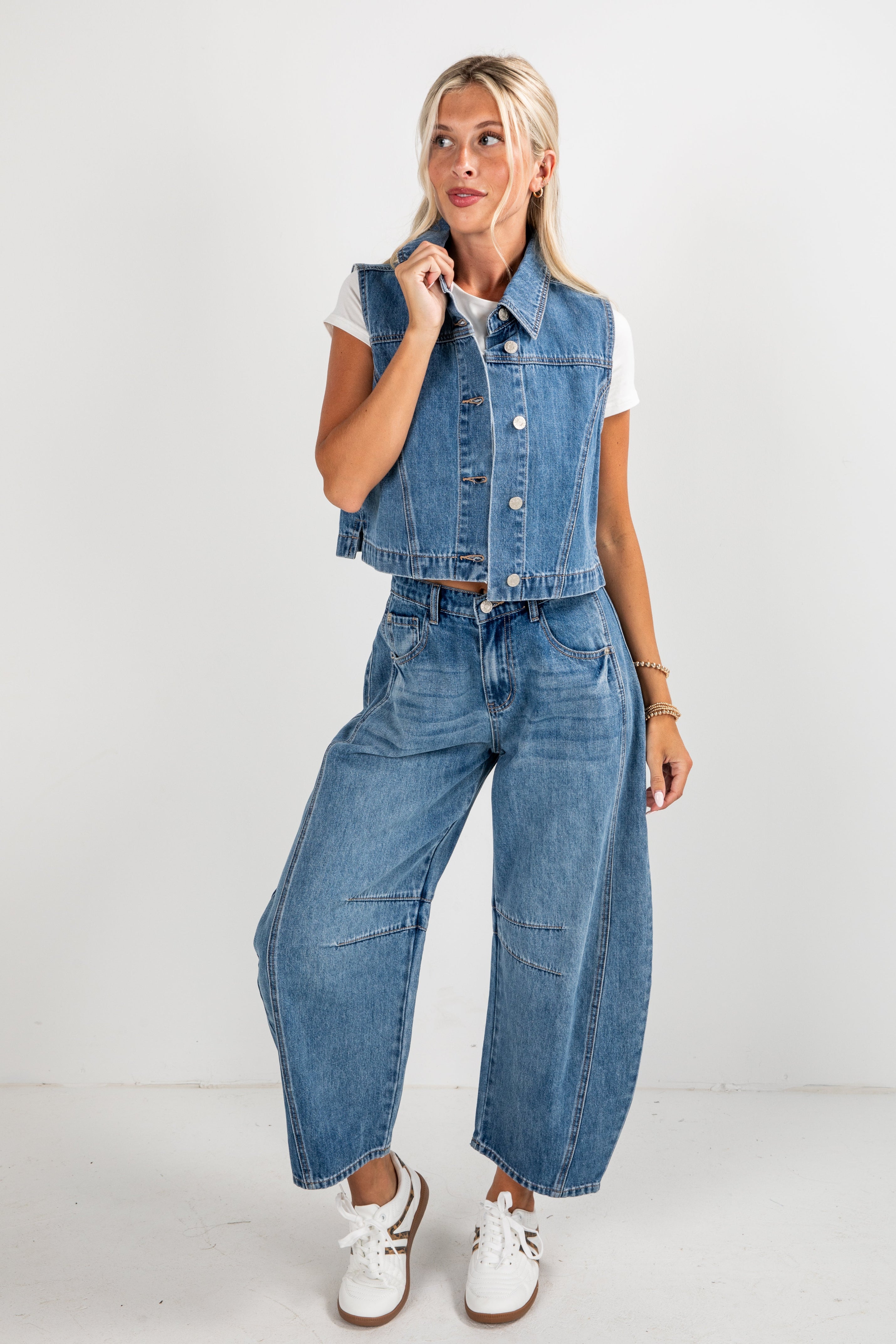 Woman wearing a denim vest and jeans on a white background