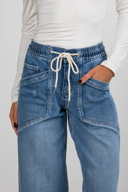 Blue jeans with a white drawstring on a plain background