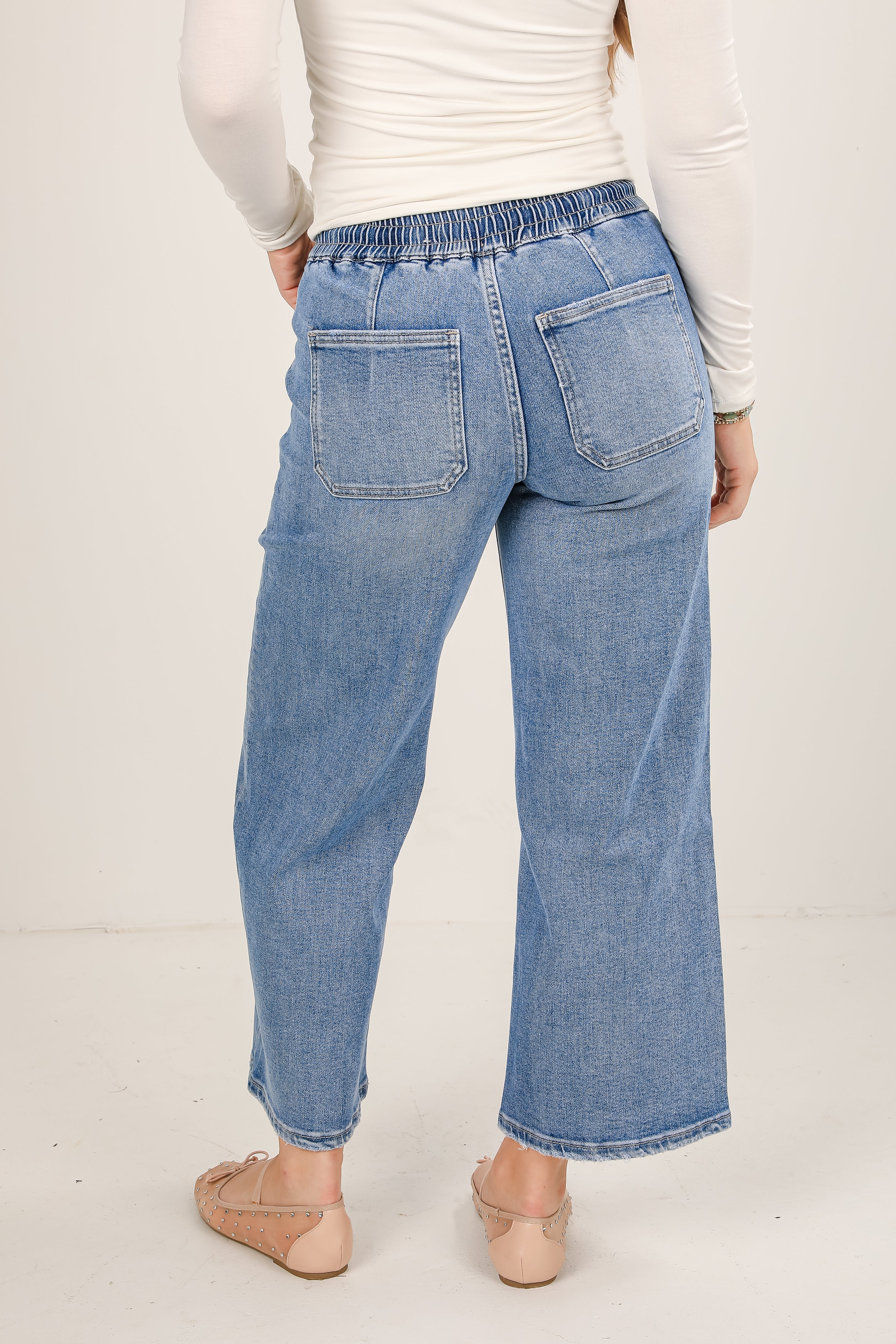 Light blue jeans worn by a person on a white background