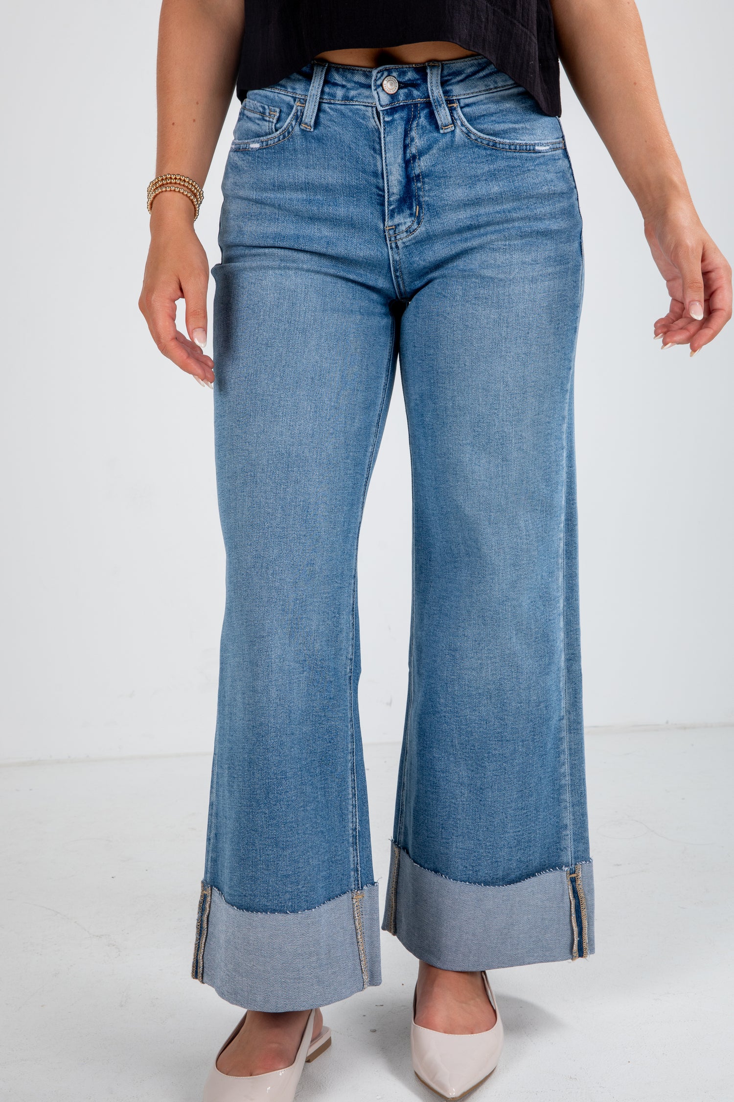 Person wearing blue flared jeans on a white background