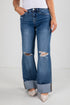 Blue jeans with a slight distressed look worn by a person on a white background