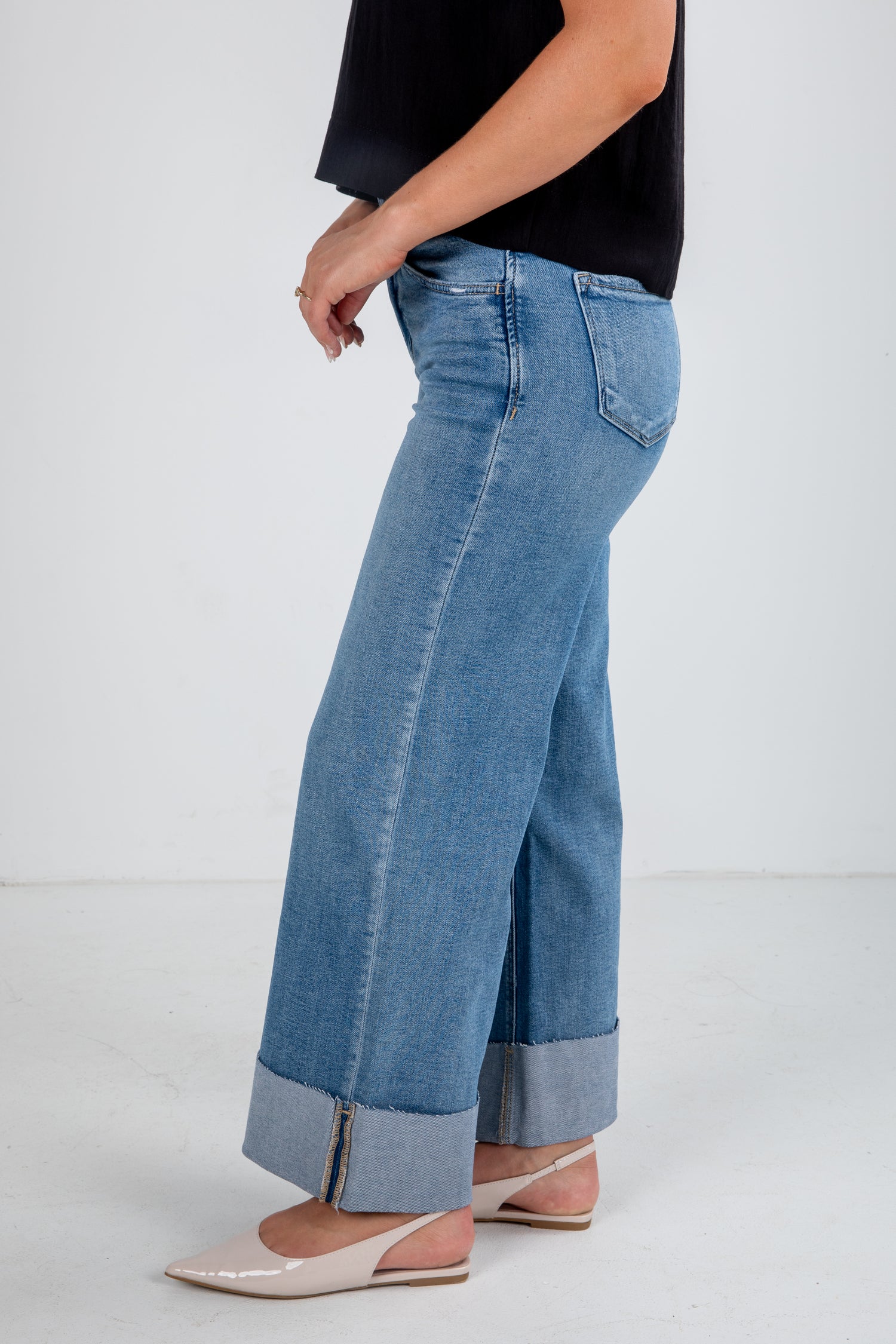 Person wearing blue jeans with a white background