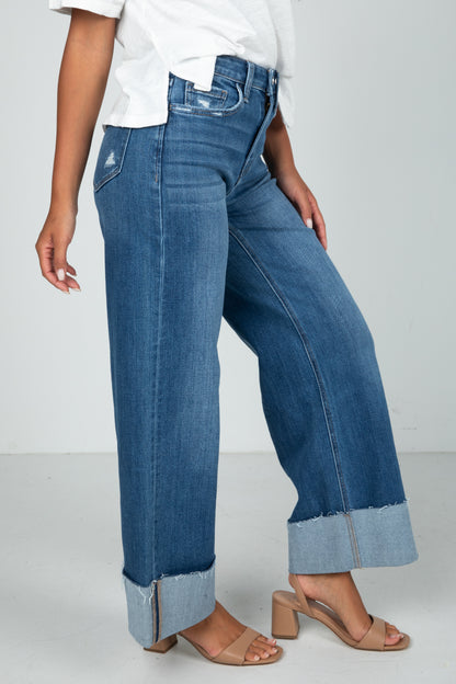 Person wearing blue wide-leg jeans on a white background