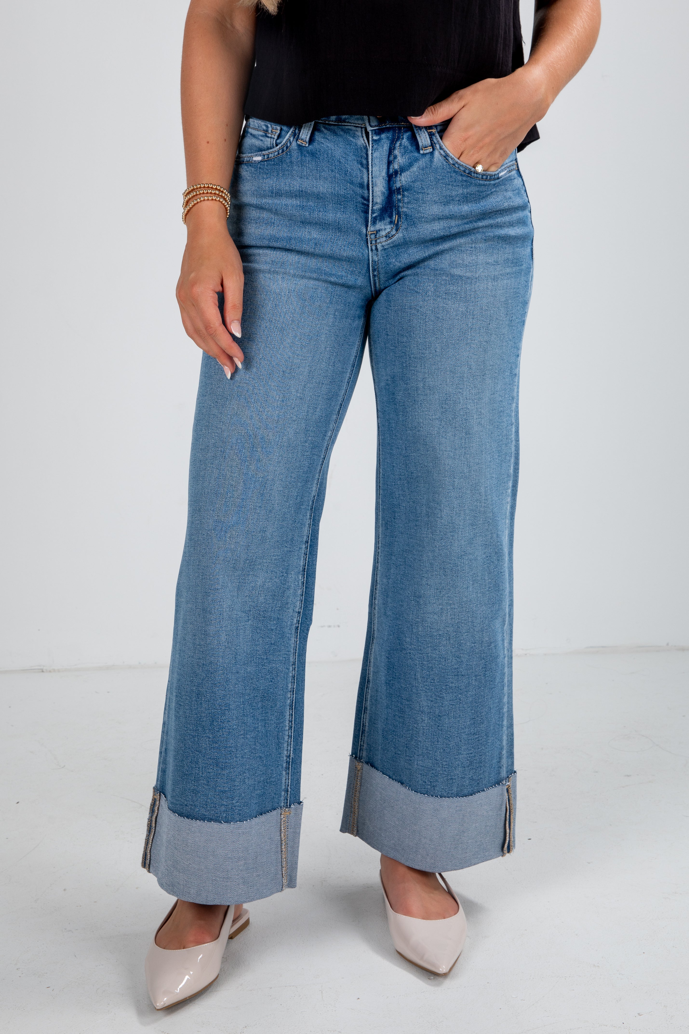 Person wearing blue wide-leg jeans on a white background