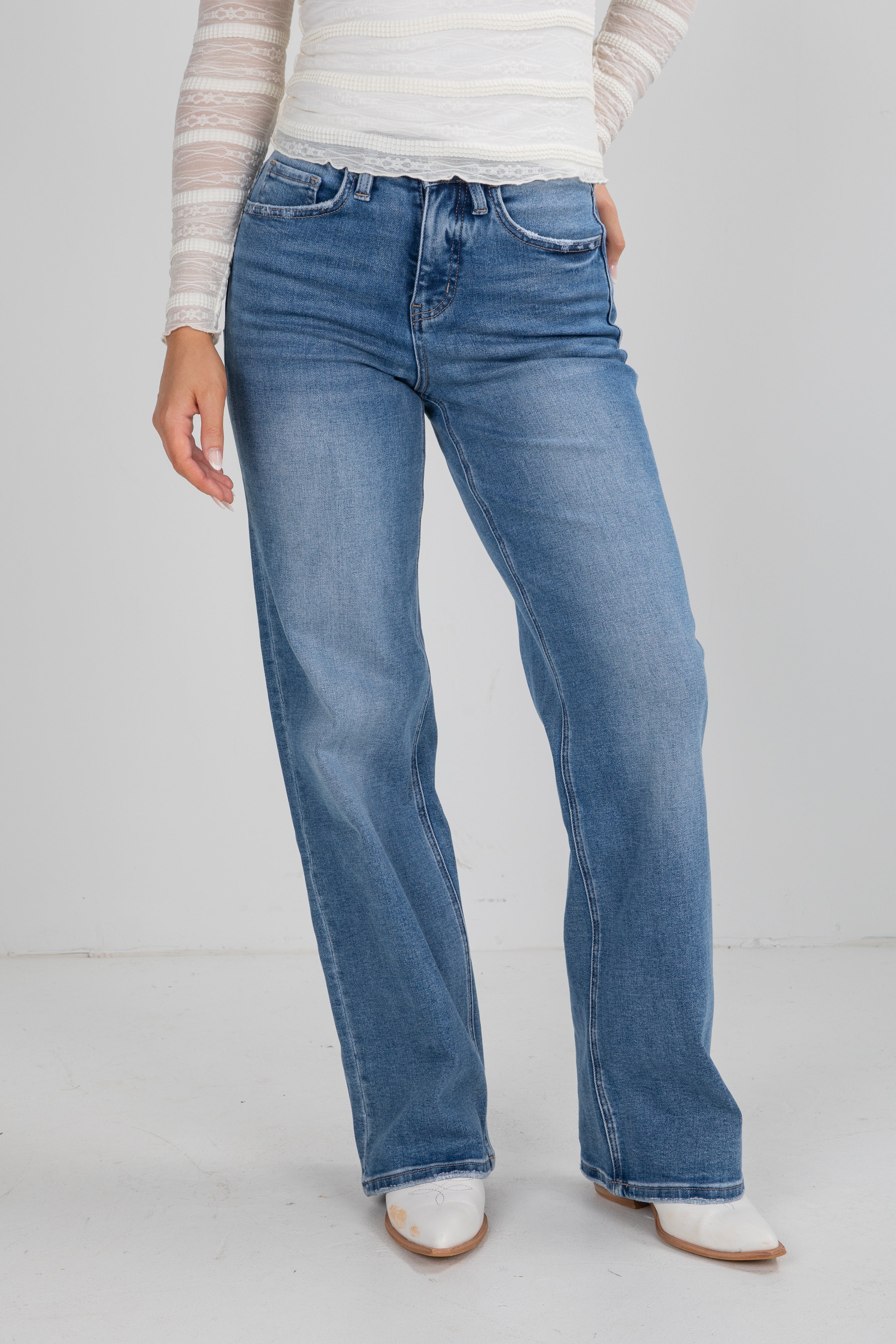 Person wearing blue jeans and a striped shirt on a white background