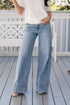 Person wearing light blue jeans on a wooden deck