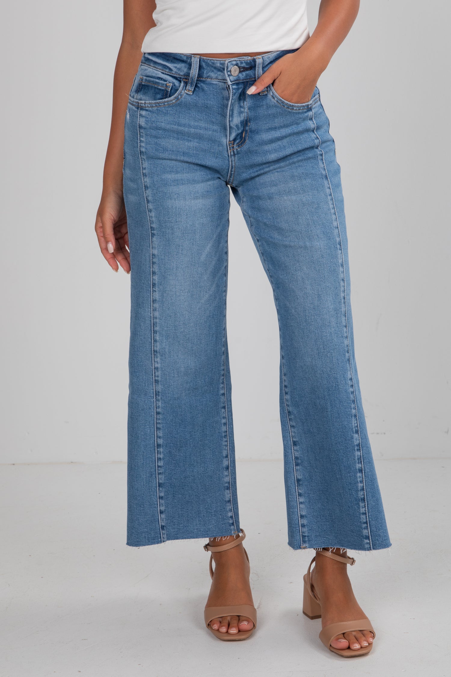 Person wearing blue jeans on a gray background