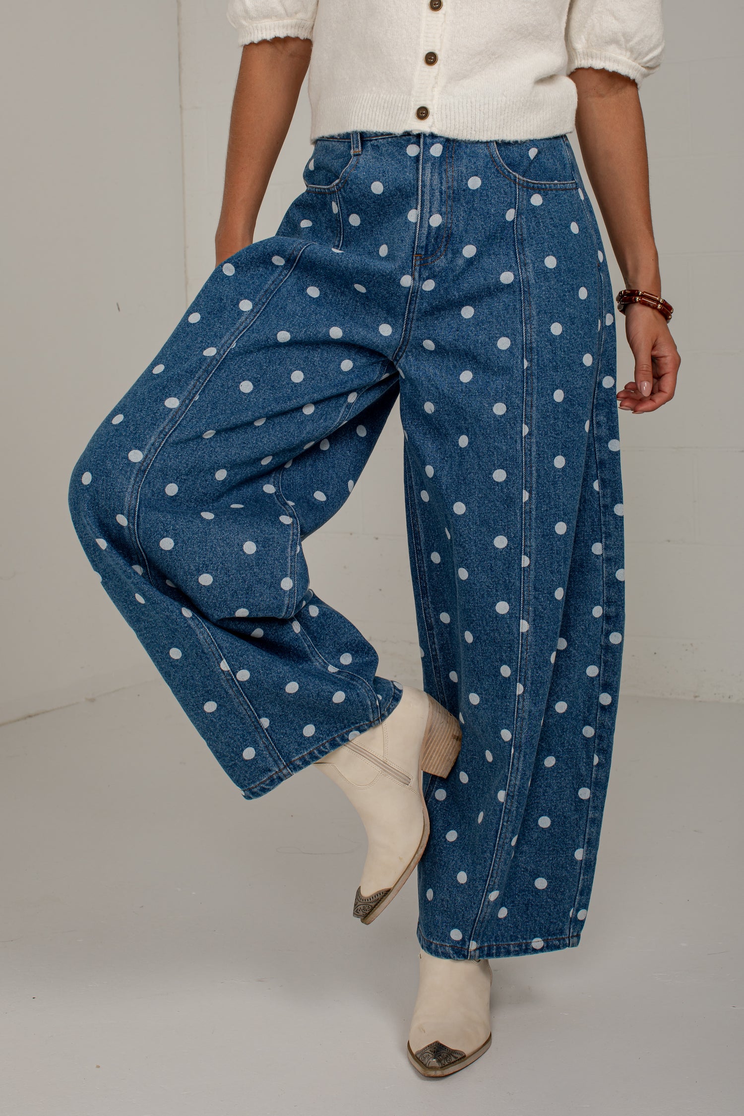 Front view of medium wash polka dot barrel jeans featuring a high-rise waist, front pockets, and curved legs.