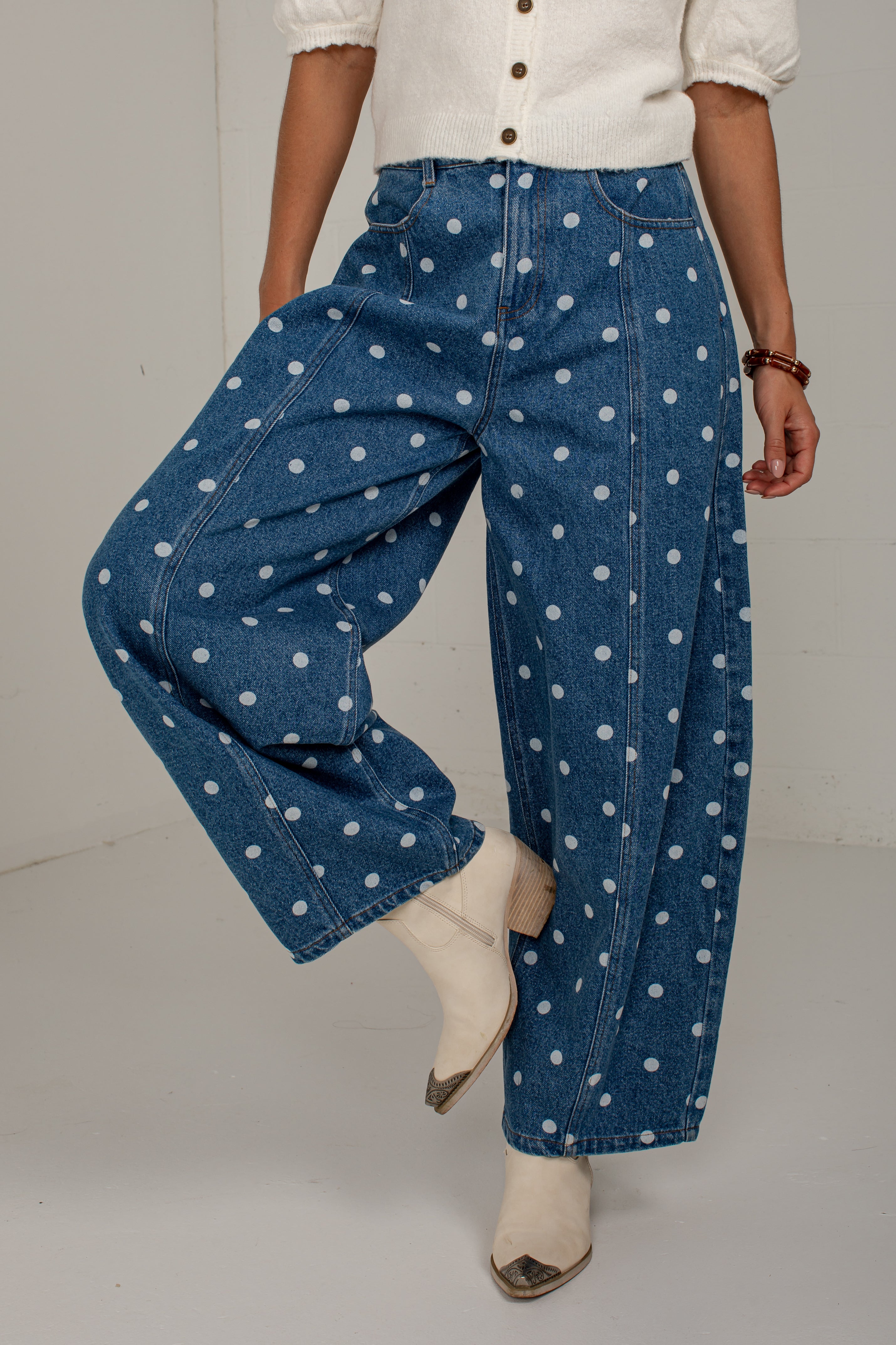 Front view of medium wash polka dot barrel jeans featuring a high-rise waist, front pockets, and curved legs.