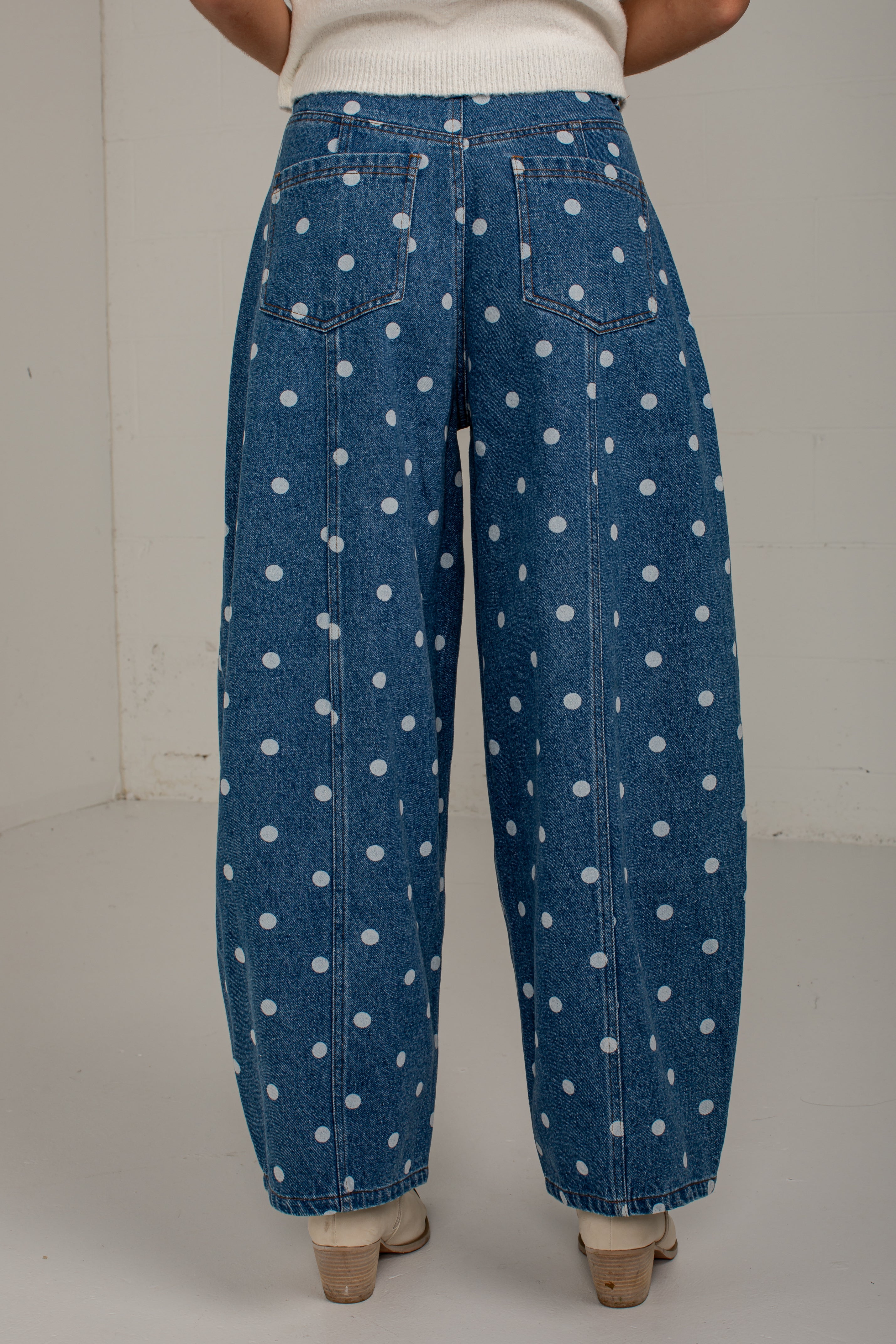 Back view of medium wash polka dot barrel jeans featuring two patch pockets and vertical seam details.