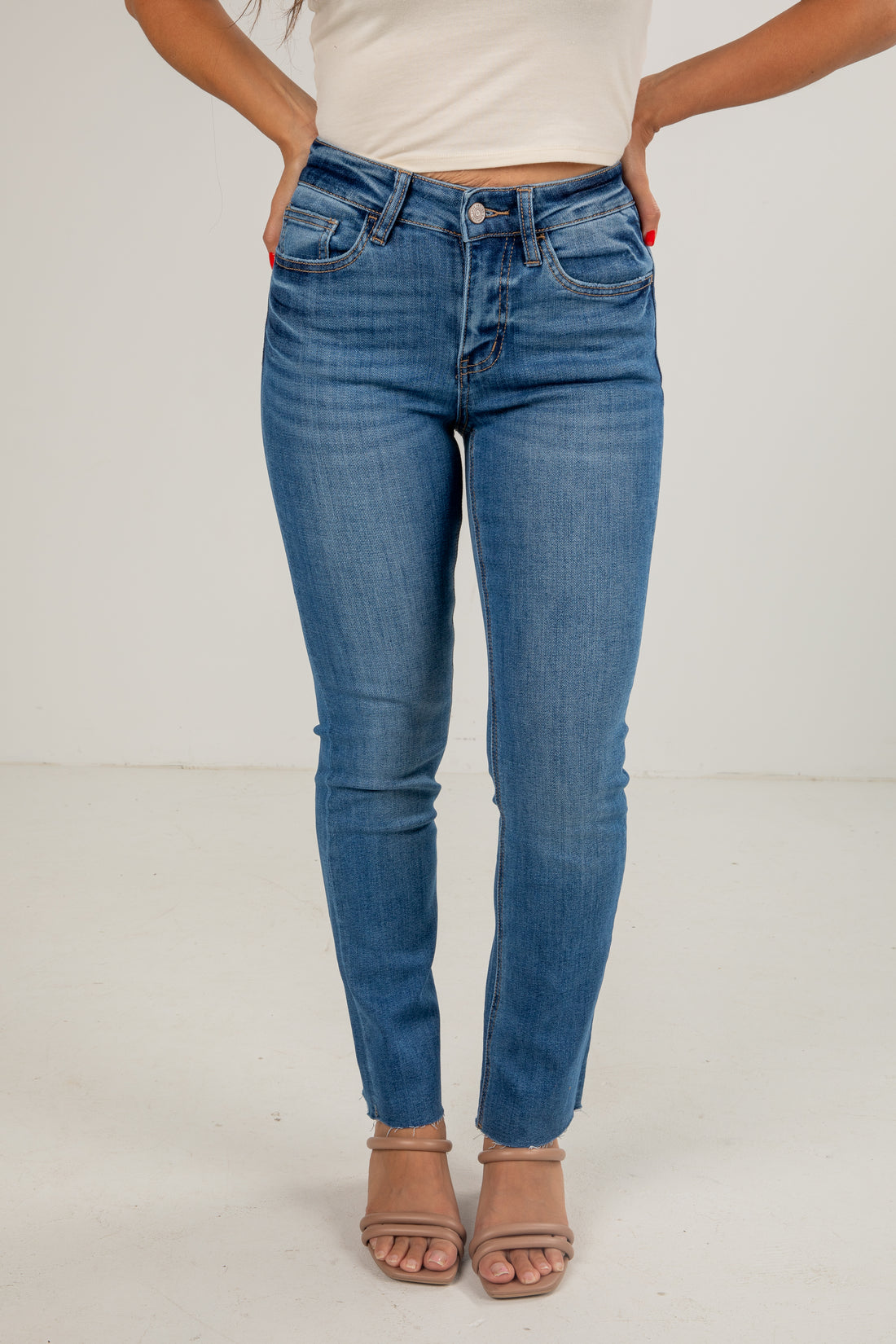 Person wearing blue jeans on a plain background