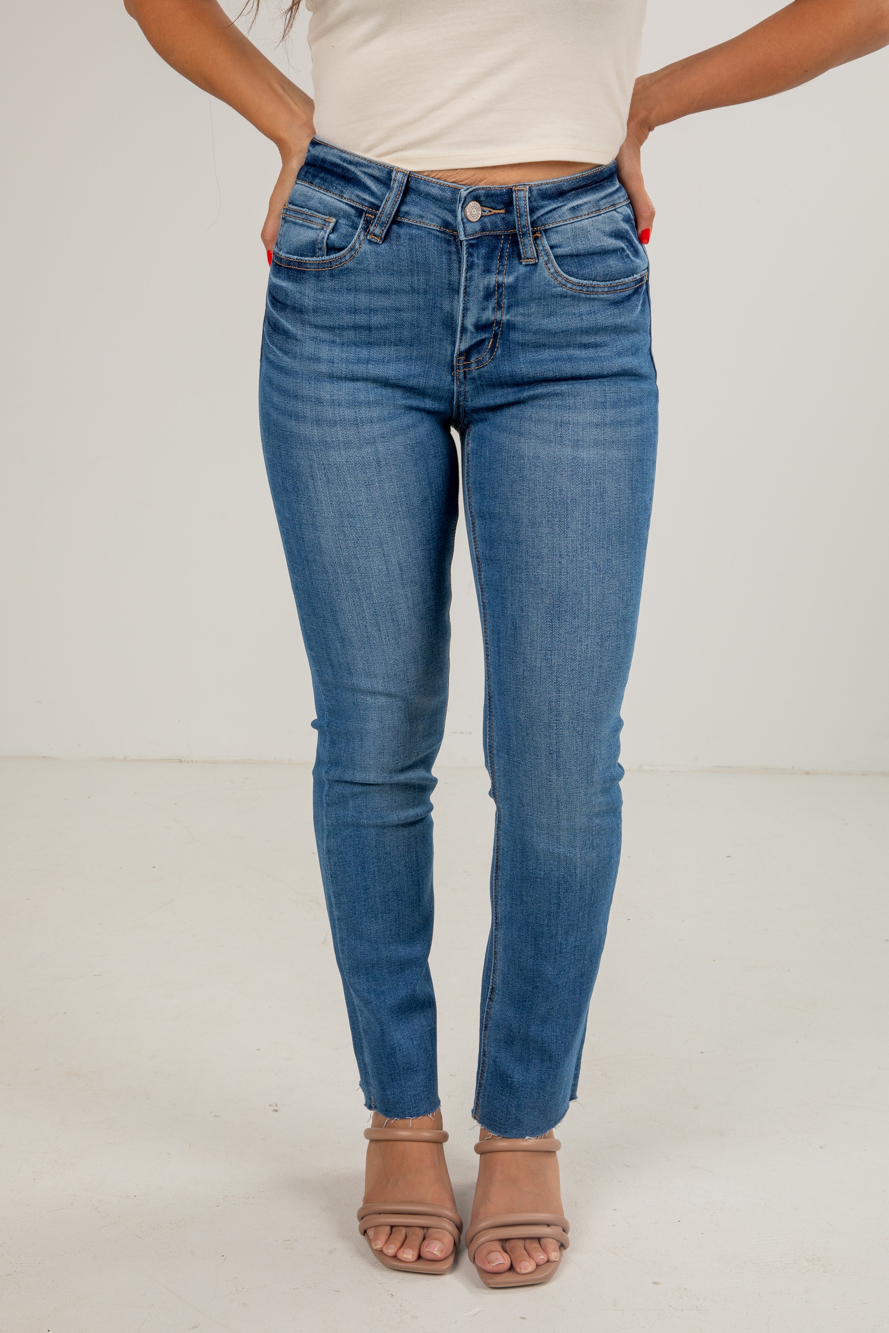 Person wearing blue jeans on a plain background