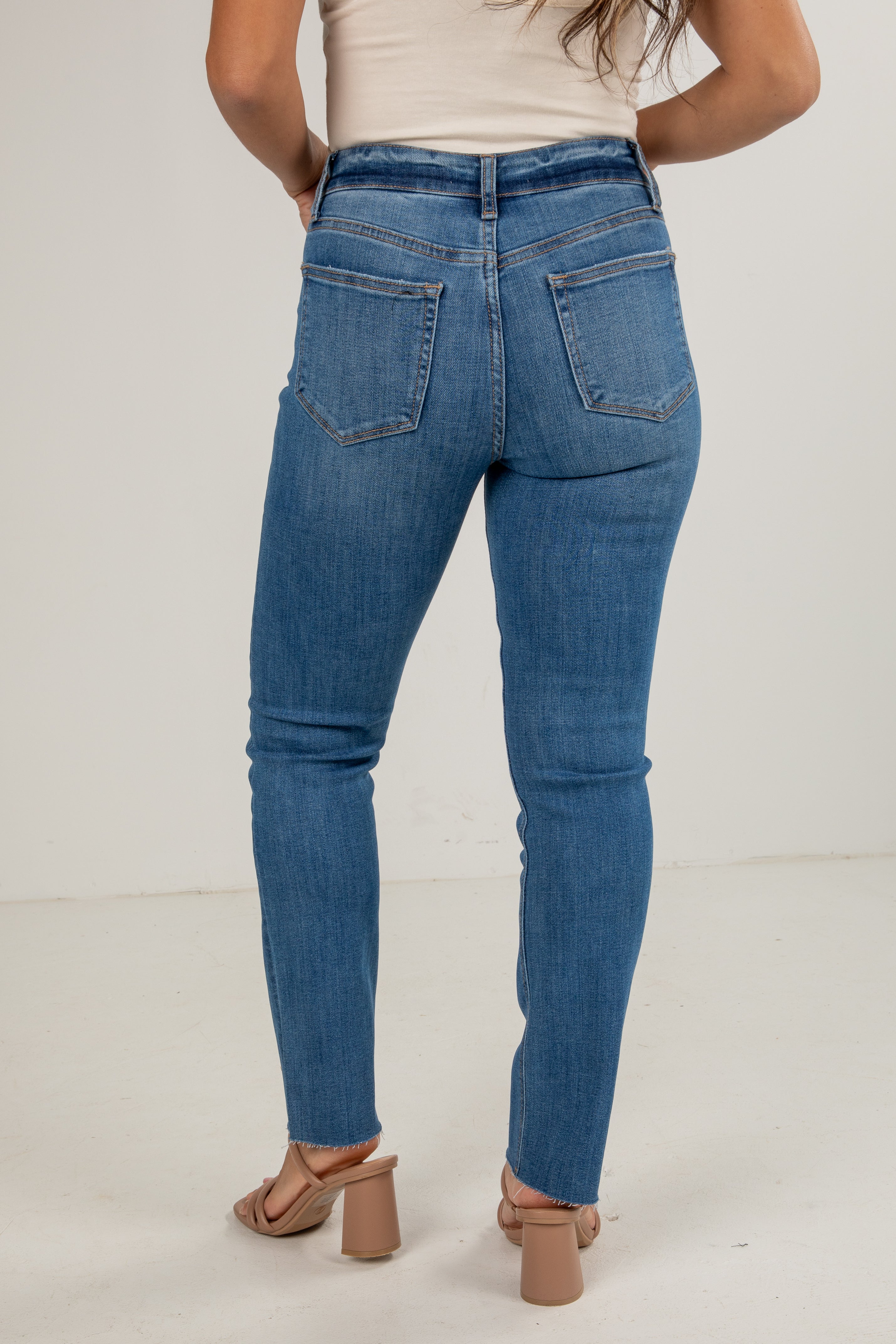 Person wearing blue jeans on a plain background