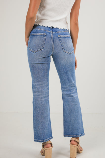 Person wearing blue jeans on a plain background