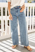 Person wearing light blue jeans on a white railing background