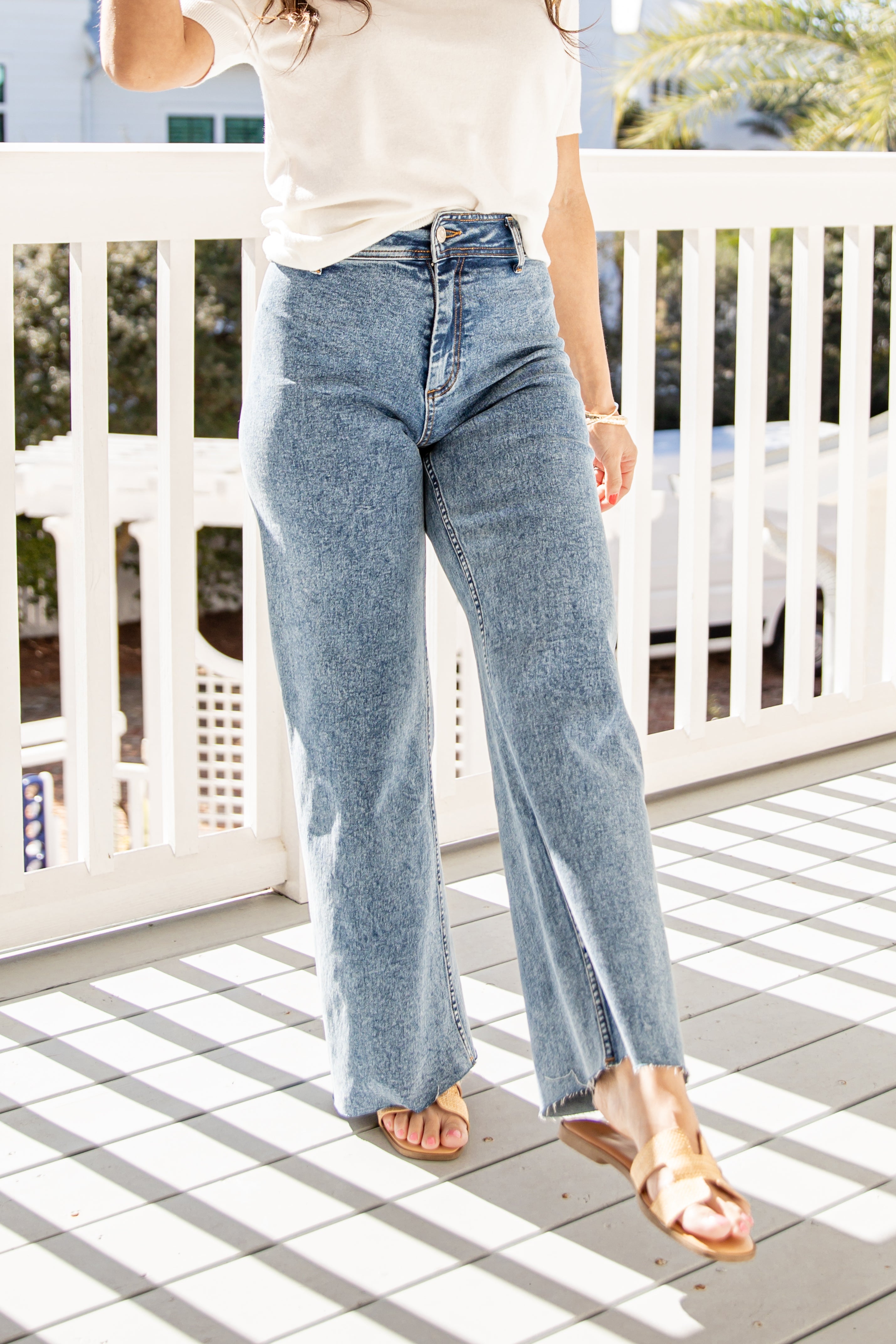 Person wearing light blue jeans on a porch