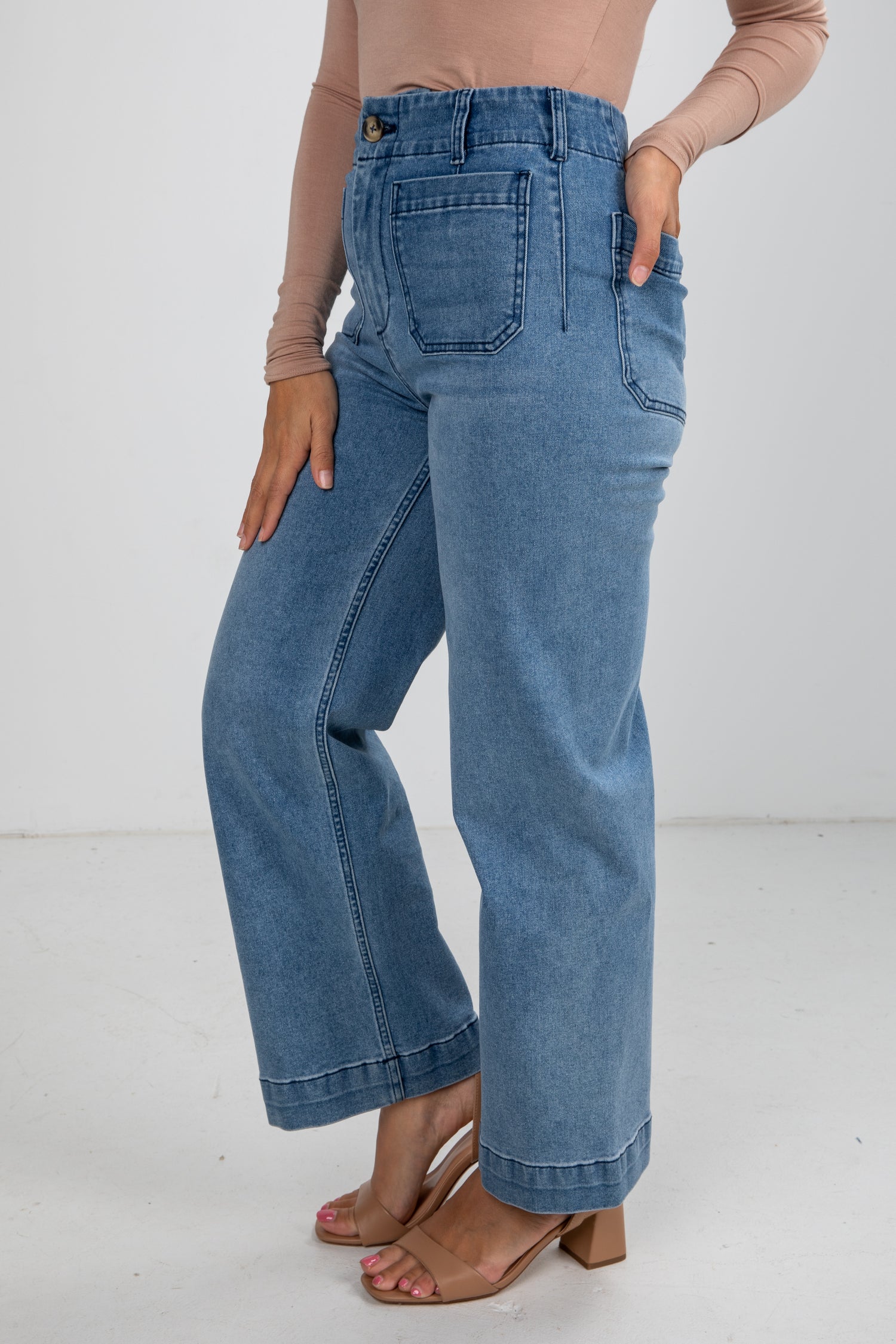 Person wearing light blue jeans on a white background