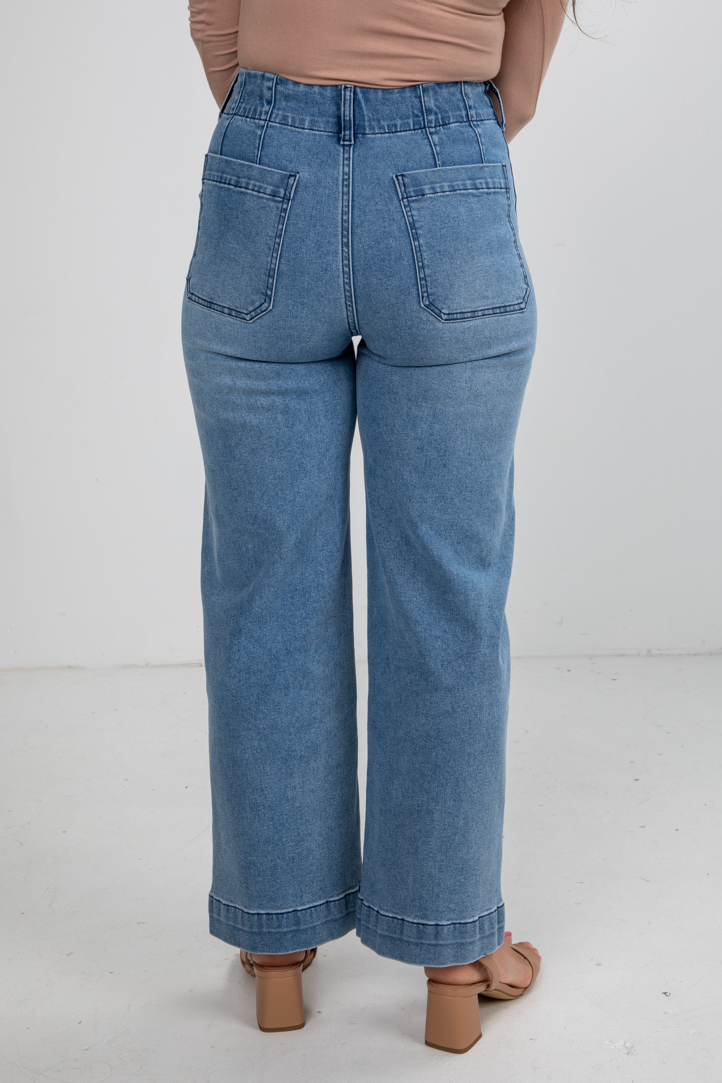 Blue jeans worn by a person on a white background