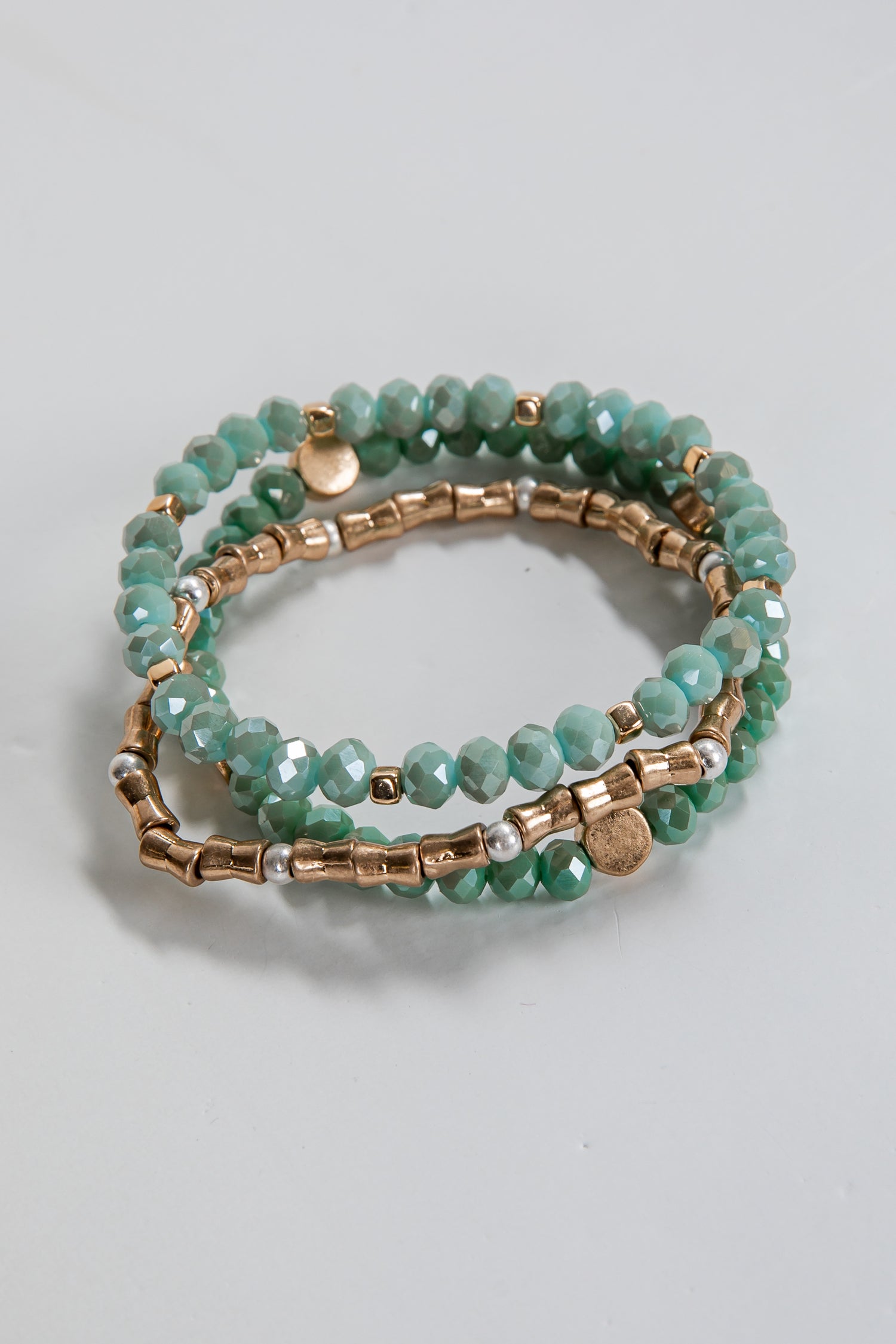 Two beaded bracelets with gold accents on a light gray background