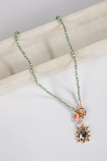 Necklace with gemstone pendant on a marble surface