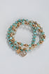 Set of turquoise and gold beaded bracelets on a light gray background