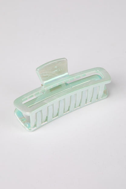Mint green hair clip on a light gray background