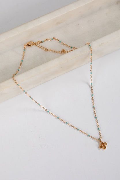 Gold bracelet with small beads on a marble surface