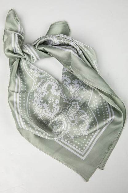 Green scarf with white pattern on a light gray background