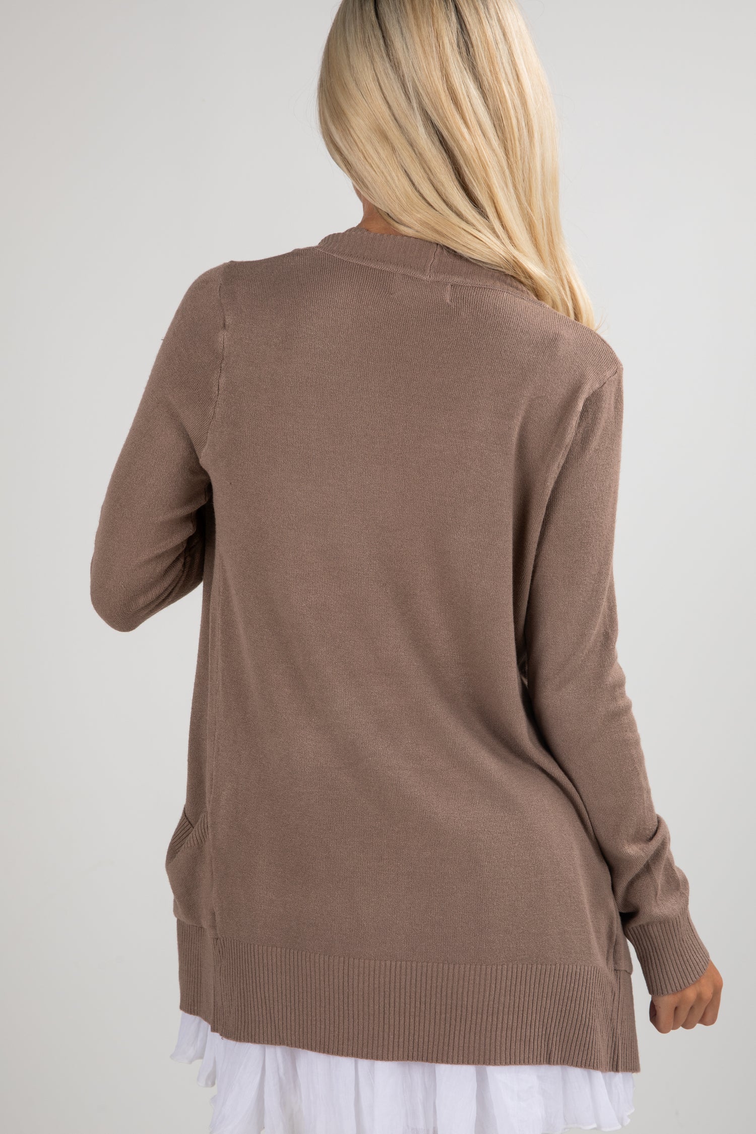 Brown cardigan worn by a person on a plain background