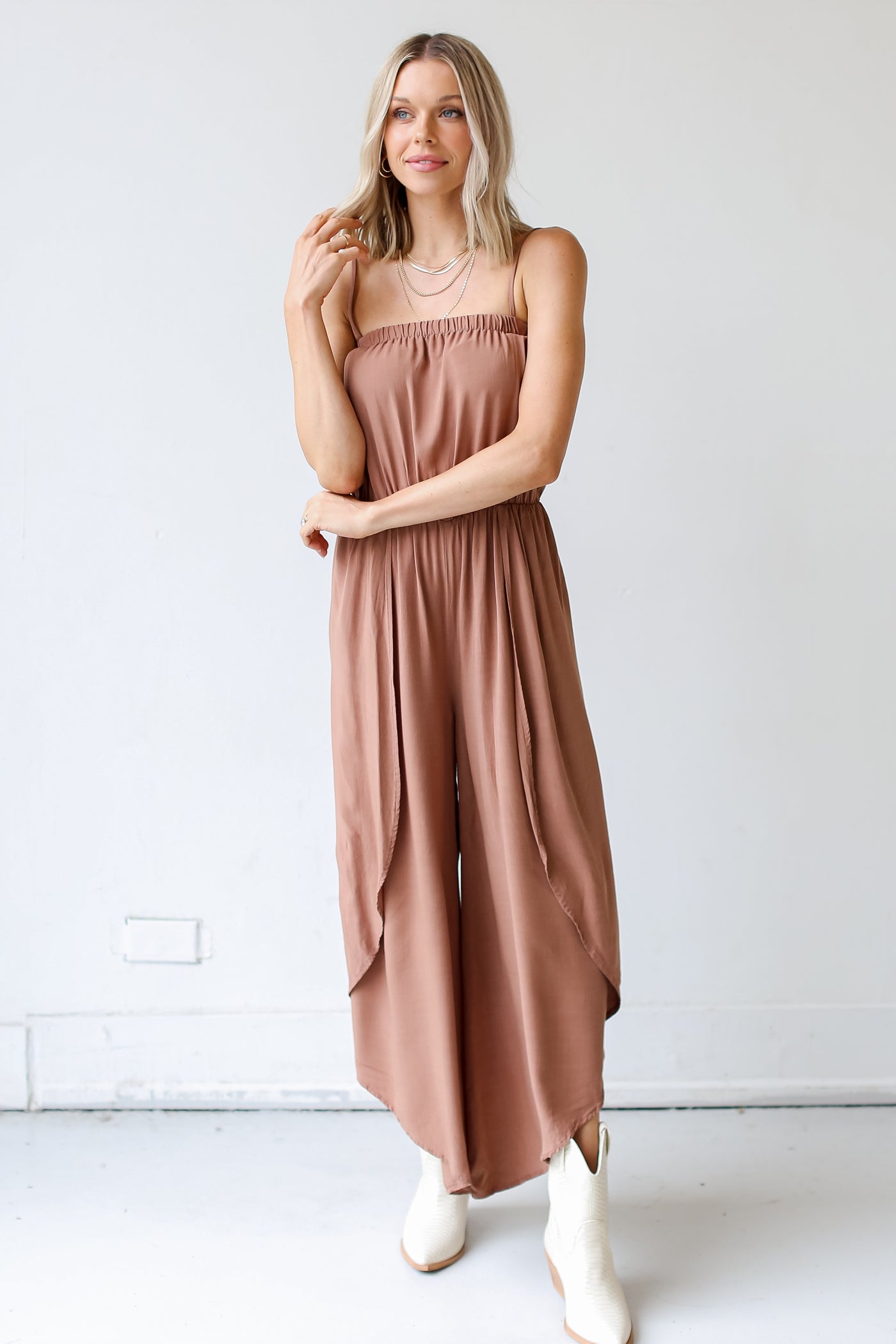 model wearing a brown Jumpsuit with white boots
