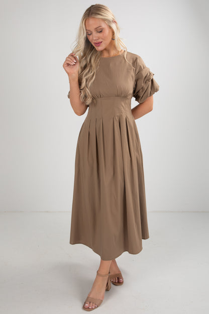 Woman wearing a brown dress on a white background
