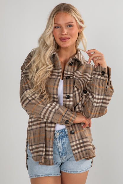 Woman wearing a plaid jacket with a plain background