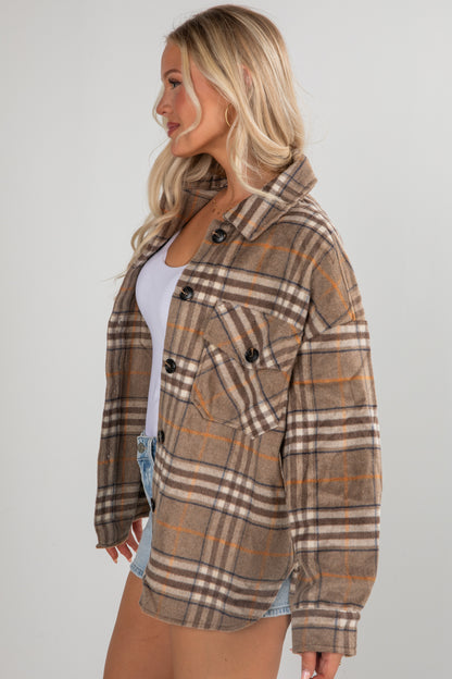 Woman wearing a plaid jacket on a plain background