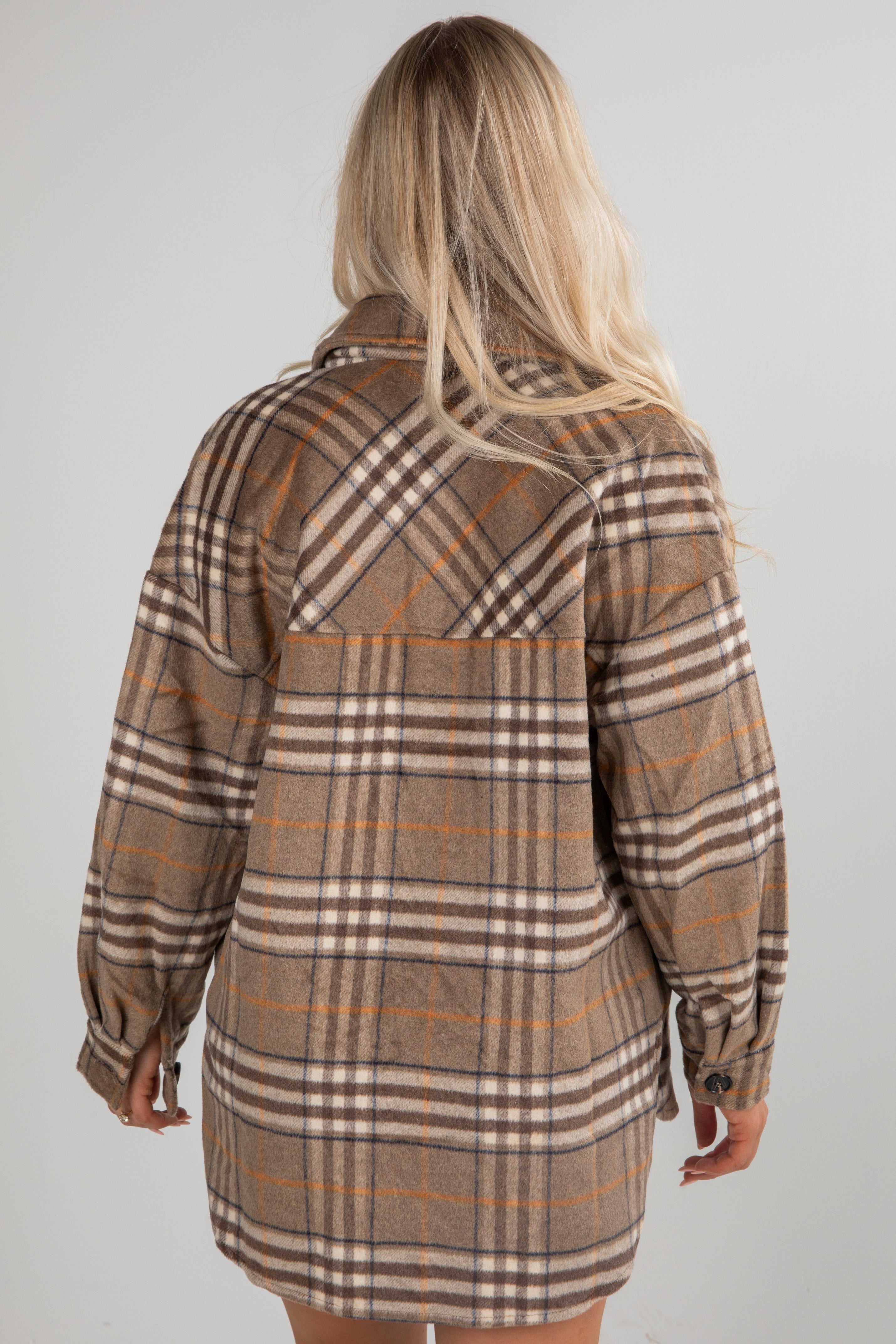 Plaid shirt dress worn by a person on a plain background