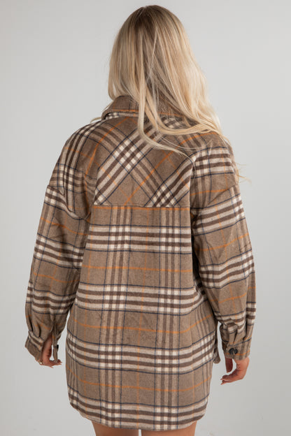 Plaid shirt dress worn by a person on a plain background