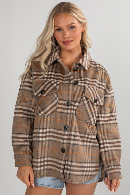 Woman wearing a plaid jacket on a plain background