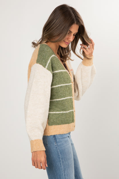 Woman wearing a green and beige striped sweater with a white background